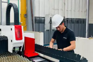 trabajador opera una maquina cortadora laser con gas