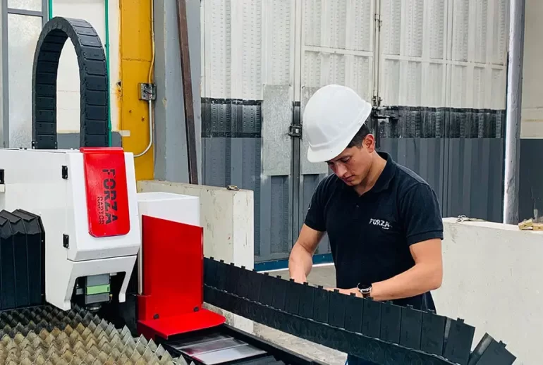 trabajador opera una maquina cortadora laser con gas